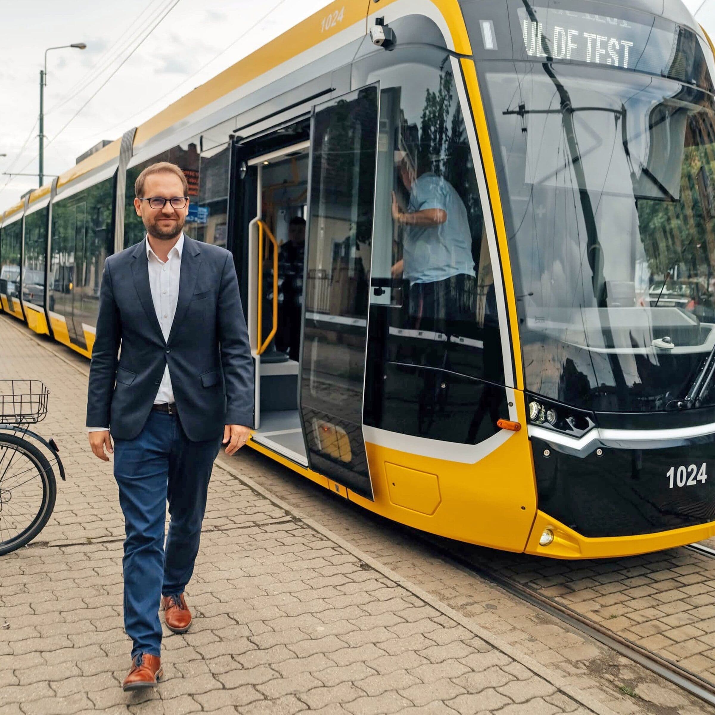 Dominic Fritz coboară dintr-un tramvai nou, galben, într-o stație din Timișoara