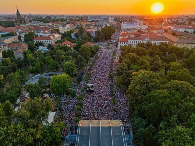 Mulțime pe un bulevard din centrul Timișoarei, văzută de sus, la apus